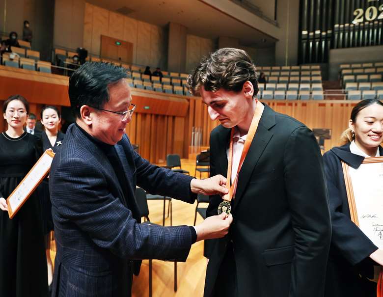 First prize winner Joshua Brown receives medal from Liguang Wang, founder of GMEL and the Competition (Image courtesy of China Conservatory of Music)